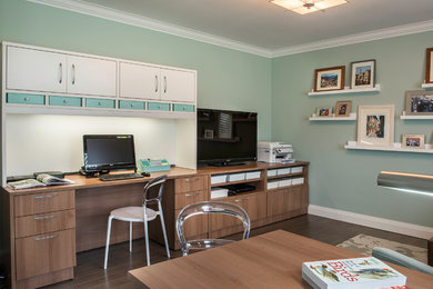 Mid-sized trendy built-in desk dark wood floor study room photo in Toronto with green walls