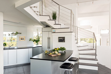 Design ideas for a beach style eat-in kitchen in Boston with an undermount sink, flat-panel cabinets, concrete floors, grey cabinets, concrete benchtops, stainless steel appliances and with island.