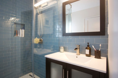 Example of a blue tile and glass tile mosaic tile floor corner shower design in Los Angeles with glass-front cabinets, black cabinets and blue walls