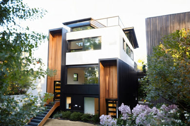 Example of a minimalist multicolored three-story mixed siding exterior home design in Vancouver with a shed roof, a metal roof and a gray roof