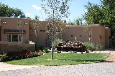 Inspiration for a large contemporary one-storey adobe beige exterior in Albuquerque with a flat roof.