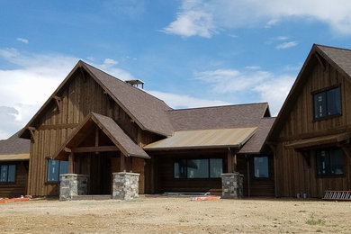 Modelo de fachada de casa marrón rústica grande de dos plantas con revestimiento de madera, tejado a dos aguas y tejado de teja de madera