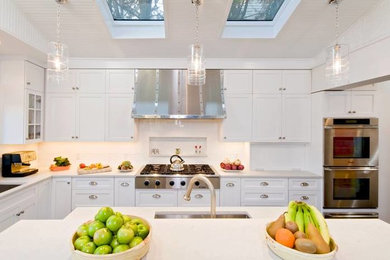 Mid-sized transitional l-shaped dark wood floor and brown floor eat-in kitchen photo in DC Metro with shaker cabinets, white cabinets, marble countertops, white backsplash, ceramic backsplash, stainless steel appliances and an island