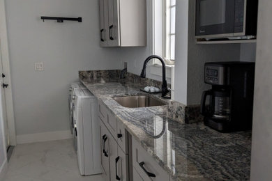 Example of a trendy galley porcelain tile and white floor utility room design with an undermount sink, gray cabinets, quartz countertops, gray walls and multicolored countertops