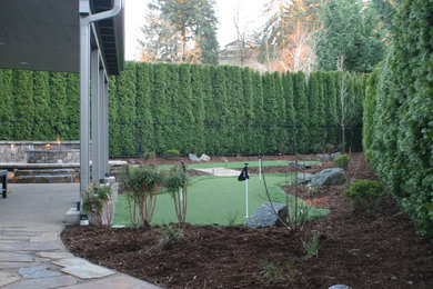 Photo of a mid-sized traditional partial sun backyard stone outdoor basketball/tennis/multi-game court in Other for winter.
