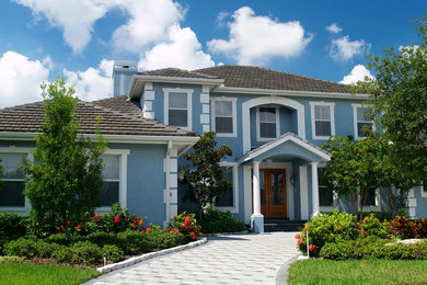 Inspiration for a large timeless blue two-story stucco exterior home remodel in Chicago