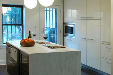 Minimalist kitchen photo in New York with flat-panel cabinets and white cabinets