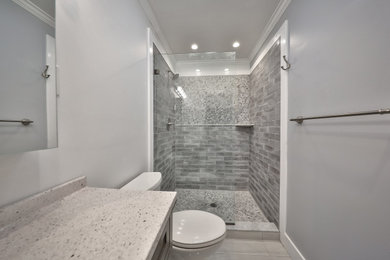 Bathroom - mid-sized contemporary master gray tile and ceramic tile porcelain tile, beige floor and single-sink bathroom idea in Philadelphia with flat-panel cabinets, gray cabinets, a one-piece toilet, blue walls, a drop-in sink, quartz countertops, gray countertops and a freestanding vanity