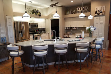 Open concept kitchen - large transitional l-shaped terra-cotta tile and brown floor open concept kitchen idea in Tampa with an undermount sink, raised-panel cabinets, white cabinets, quartz countertops, multicolored backsplash, mosaic tile backsplash, stainless steel appliances and an island