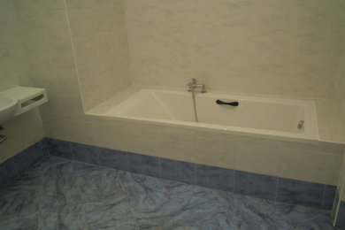 Immagine di un grande bagno di servizio design con ante bianche, WC a due pezzi, piastrelle bianche, piastrelle in ceramica, pareti bianche, pavimento con piastrelle in ceramica, lavabo a bacinella e top piastrellato