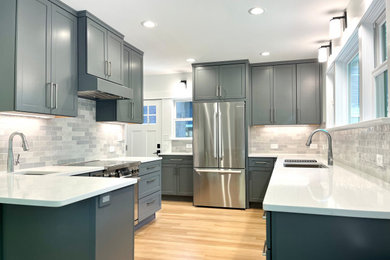 Example of a small transitional galley light wood floor and yellow floor eat-in kitchen design in Portland with an undermount sink, shaker cabinets, gray cabinets, quartz countertops, gray backsplash, ceramic backsplash, stainless steel appliances, a peninsula and white countertops