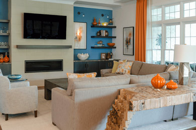 Modelo de sala de estar abierta clásica renovada grande con paredes azules, suelo de madera en tonos medios, todas las chimeneas, marco de chimenea de baldosas y/o azulejos y suelo marrón