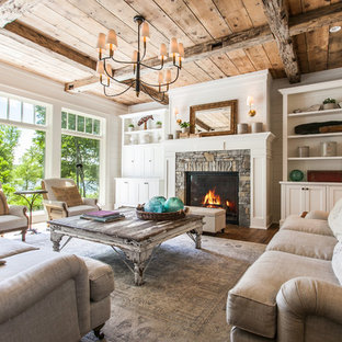 Foto de salón para visitas abierto, de estilo de casa de campo, sin televisor, con paredes blancas, suelo de madera en tonos medios, chimenea tradicional, marco de chimenea de piedra y suelo marrón