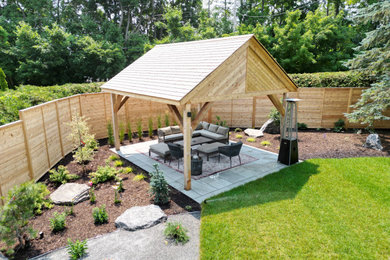 Photo of a backyard wood fence landscaping in Ottawa with a pergola.