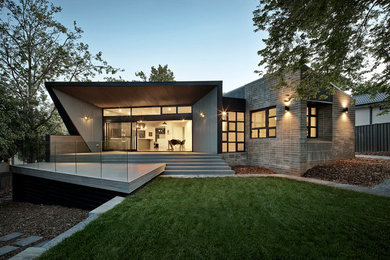 Inspiration for a contemporary one-storey grey exterior in Melbourne with a flat roof.