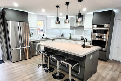 Trendy l-shaped medium tone wood floor and brown floor eat-in kitchen photo in Toronto with a double-bowl sink, flat-panel cabinets, white cabinets, quartz countertops, white backsplash, stainless steel appliances, an island and gray countertops