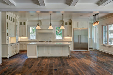 Inspiration for a large transitional galley open plan kitchen in Orlando with recessed-panel cabinets, white cabinets, white splashback, ceramic splashback, stainless steel appliances, with island, granite benchtops, an undermount sink and dark hardwood floors.