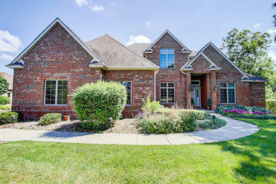 Large elegant red three-story brick exterior home photo in Milwaukee