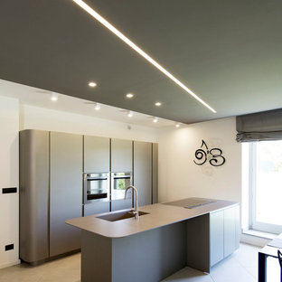 Contemporary kitchen pantry ideas - Inspiration for a contemporary single-wall kitchen pantry remodel in Turin with flat-panel cabinets, gray cabinets and an island