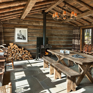 Kleines Uriges Esszimmer mit brauner Wandfarbe, Kaminofen, Kaminsims aus Metall und blauem Boden in Sonstige