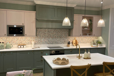 Inspiration for a classic kitchen/diner in Edinburgh with a single-bowl sink, shaker cabinets, green cabinets, composite countertops, ceramic splashback, medium hardwood flooring, an island, white worktops and a chimney breast.