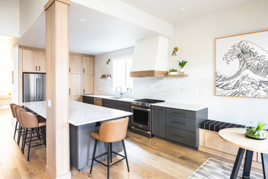 1960s medium tone wood floor kitchen photo in Other with flat-panel cabinets, light wood cabinets, quartz countertops, ceramic backsplash, stainless steel appliances, an island and white countertops