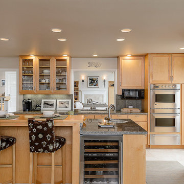 The kitchen features warm woods, gleaming stainless, and modern appliances.