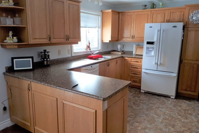 Kitchen - mid-sized l-shaped kitchen idea in Other with raised-panel cabinets, light wood cabinets and a peninsula