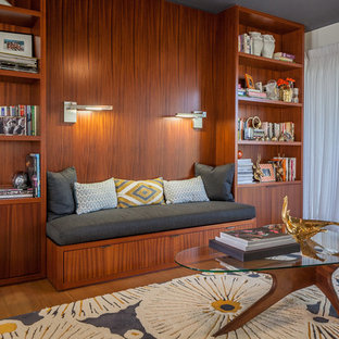 Modern inredning av ett hemmabibliotek, med orange väggar och brunt golv