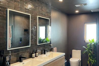 Ejemplo de cuarto de baño principal, doble y flotante minimalista grande con puertas de armario de madera clara, bañera exenta, ducha abierta, baldosas y/o azulejos negros, paredes negras y encimeras blancas