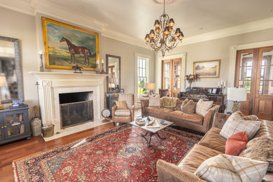Example of a classic light wood floor living room design in Nashville with a standard fireplace and a wood fireplace surround