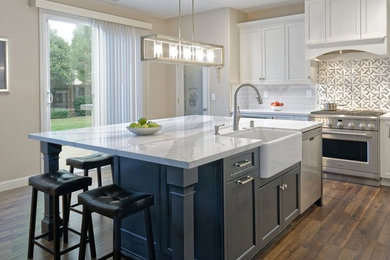 Mid-sized transitional l-shaped medium tone wood floor and brown floor eat-in kitchen photo in San Francisco with a farmhouse sink, black cabinets, quartz countertops, gray backsplash, ceramic backsplash, stainless steel appliances, an island and white countertops