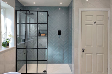 Design ideas for a large modern family bathroom in London with black cabinets, a freestanding bath, a walk-in shower, blue tiles, ceramic tiles, porcelain flooring, granite worktops, black worktops, a feature wall, double sinks and a built in vanity unit.