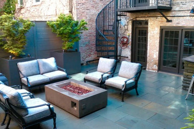 Trendy backyard stone patio container garden photo in Chicago