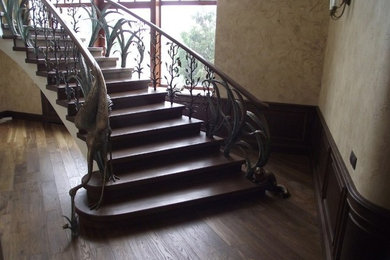 Cette image montre un grand escalier traditionnel en U avec des marches en bois et des contremarches en bois.