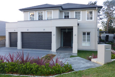 Photo of a large two-storey beige exterior in Sydney with a hip roof.