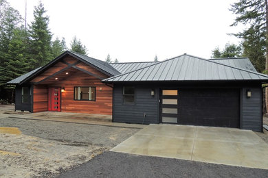 Example of a trendy black one-story mixed siding exterior home design in Seattle with a metal roof