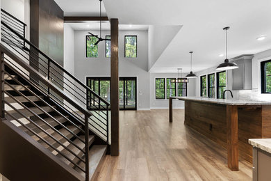 Large trendy l-shaped vinyl floor and brown floor kitchen pantry photo in Raleigh with recessed-panel cabinets, gray cabinets, quartz countertops, gray backsplash, ceramic backsplash, stainless steel appliances, an island and multicolored countertops