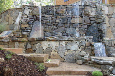 This is an example of a traditional backyard garden in Atlanta with a water feature.