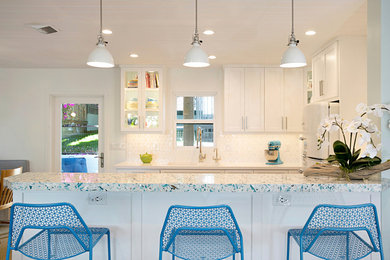 Example of a small beach style u-shaped medium tone wood floor and brown floor open concept kitchen design in San Diego with an undermount sink, shaker cabinets, white cabinets, quartz countertops, white backsplash, ceramic backsplash and white appliances