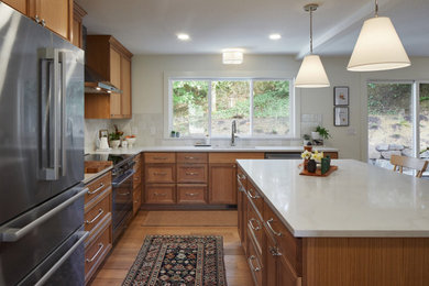 Mid-sized minimalist u-shaped medium tone wood floor and brown floor eat-in kitchen photo in Portland with an undermount sink, shaker cabinets, dark wood cabinets, quartz countertops, white backsplash, ceramic backsplash, stainless steel appliances, an island and white countertops