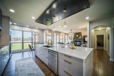 Large minimalist dark wood floor, brown floor and coffered ceiling open concept kitchen photo in Little Rock with an undermount sink, flat-panel cabinets, gray cabinets, quartz countertops, white backsplash, quartz backsplash, stainless steel appliances, an island and white countertops