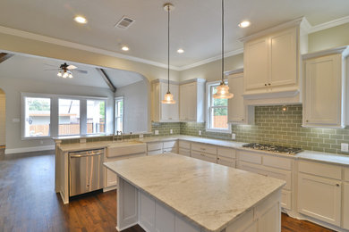 Inspiration for a timeless medium tone wood floor kitchen remodel in Dallas with a farmhouse sink, shaker cabinets, white cabinets, marble countertops, green backsplash, glass tile backsplash, stainless steel appliances and an island