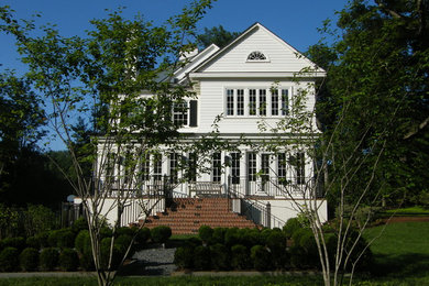 Inspiration for a huge timeless white three-story brick gable roof remodel in New York