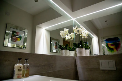 Photo of a small contemporary cloakroom in Other with white cabinets, a wall mounted toilet, grey tiles, porcelain tiles, grey walls, porcelain flooring, a wall-mounted sink and grey floors.