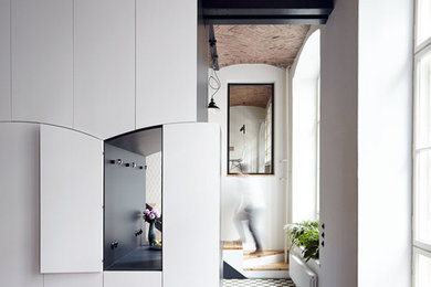 Diseño de despacho urbano con paredes blancas, suelo de ladrillo y suelo multicolor