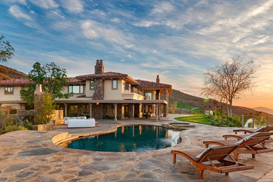 Inspiration for a huge mediterranean beige two-story mixed siding exterior home remodel in Los Angeles with a tile roof