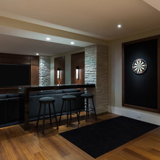 Photo of a large contemporary enclosed home cinema in Vancouver with beige walls, medium hardwood flooring and a built-in media unit.