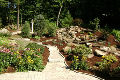 Photo of a large rustic full sun backyard brick landscaping in New York.