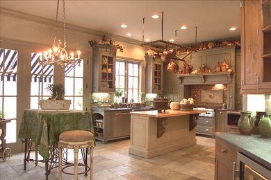 Inspiration for a mid-sized traditional u-shaped eat-in kitchen in San Diego with a farmhouse sink, raised-panel cabinets, green cabinets, soapstone benchtops, brown splashback, brick splashback, stainless steel appliances, ceramic floors, with island and beige floor.